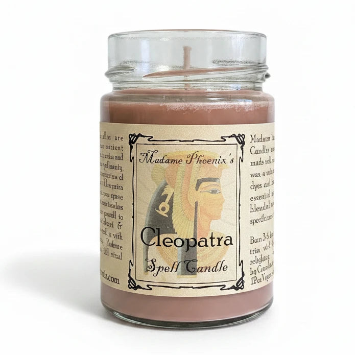 Candle jar labeled 'Cleopatra' on a natural background with plants